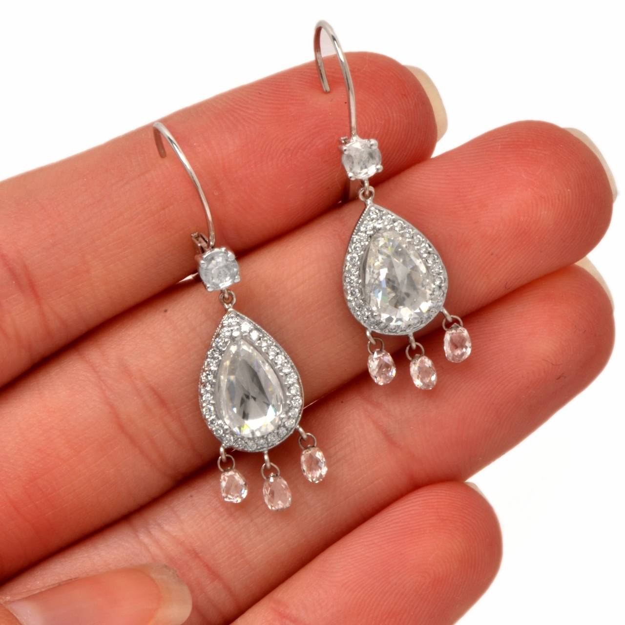 These aesthetically enchanting antique design pendant earrings with Pear-shape and round-faceted diamonds are crafted in solid 18K white gold, weighing 6.00 grams and measuring 1.3