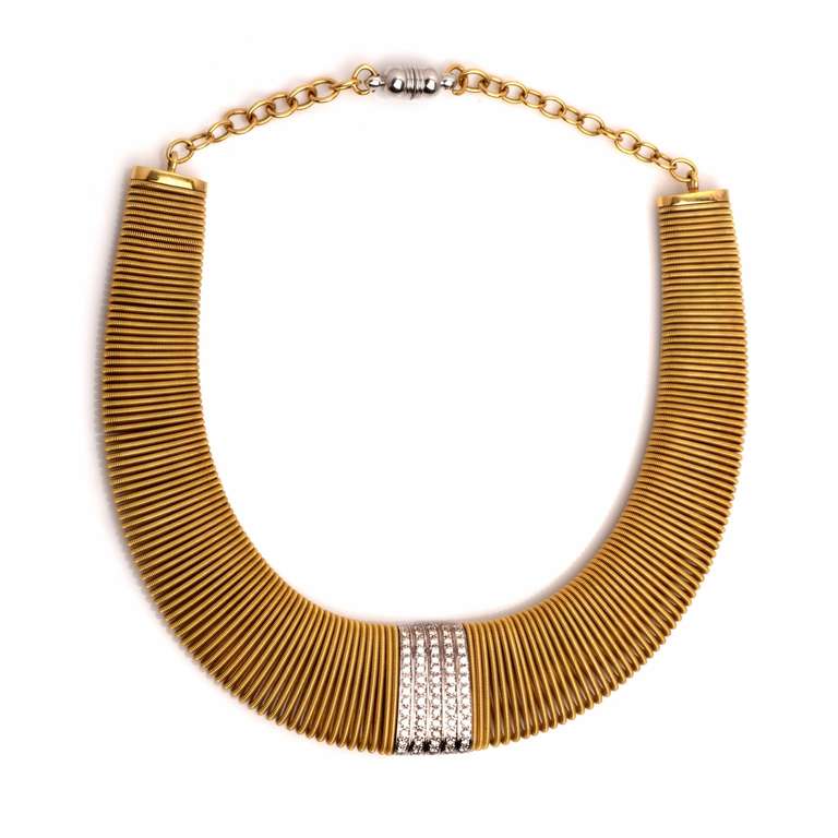 This elegant vintage Retro necklace is crafted in a combination of solid 18k yellow and white gold. This  fine and feminine piece which  would certainly serve as a unique neck adornment,  is designed with a snake mesh pattern and a sparkling central