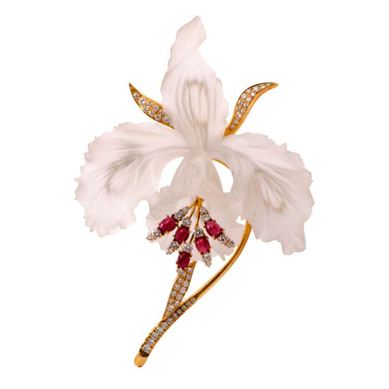 This alluring European lapel brooch is crafted in solid 18K yellow gold and weighs approx. 56.6 grams. It is designed as an enchanting orchid on stem, with ruby and diamond 'buds' creating a color-contrasting aesthetic. The orchid petals are