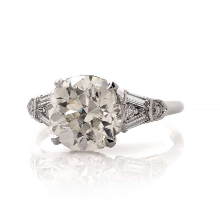 This antique engagement ring is crafted in solid platinum, weighing approx. 4.0 grams and measuring approx. 9 mm x 9 mm. Elegant in design, this delicate engagement ring exposes a round European cut diamond weighing approx. 3.16 ct, graded I-J color