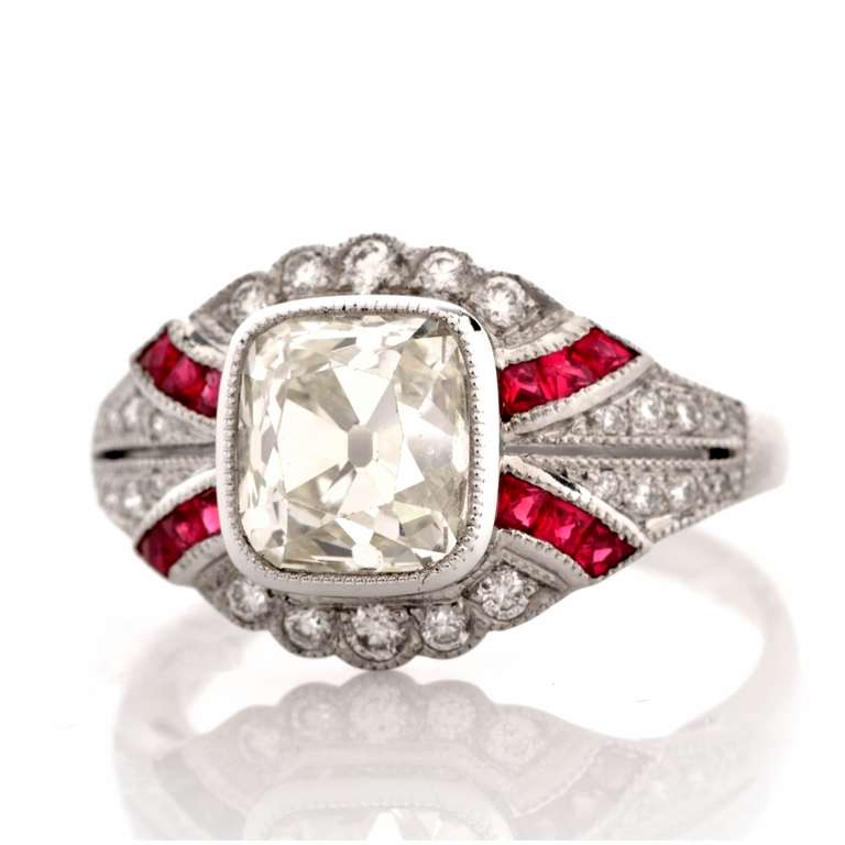 This exquisite engagement ring with a breath-taking approx. 2.39 ct cushion-cut diamond in the center and rubies is crafted in platinum, weighs approx. 5.3 grams and measures 20mm long and 10mm wide. This color-contrasted engagement ring exposes at