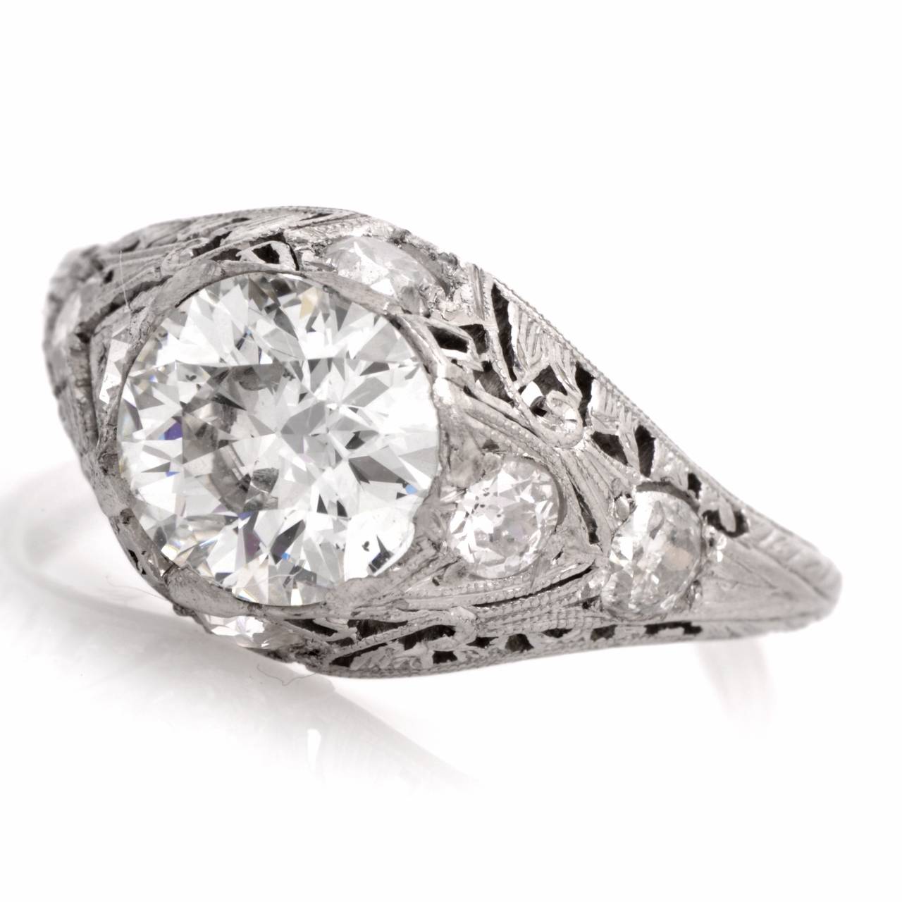 This antique 1930's filigree engagement ring of immaculate artistic workmanship is crafted in solid platinum, weighs approximately 4.2 grams and measures 6 mm high. Designed as a gracefully  domed  plaque, this fascinating vintage engagement ring