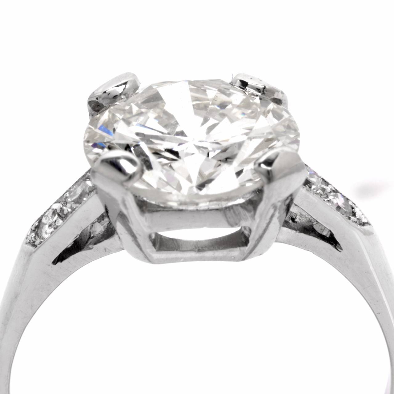 This diamond engagement ring is crafted in platinum, weighing 4.9 grams. This authentic vintage engagement ring exposes an outstanding 3.49 ct  round-faceted diamond graded  J-K  color and VS clarity, mounted within a basket-shaped openwork setting.