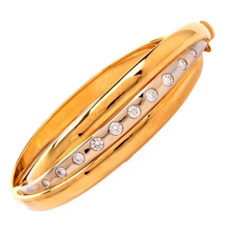 This bangle bracelet of creative and impressive design is crafted in a combination of solid 18K yellow and white gold, weighing approx. 55.3 grams and measuring approx. 7 1/4