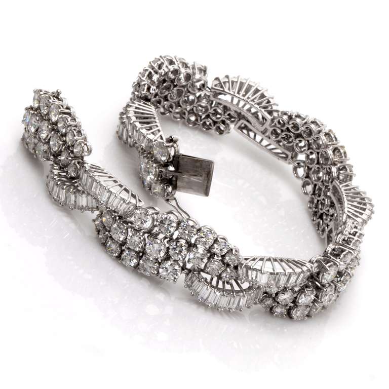 This estate bracelet encrusted in 25.74cts of baguette and round brilliant-cut diamonds is crafted in solid 18k white gold, weighing approx. 36.2 grams and measuring approx. 7