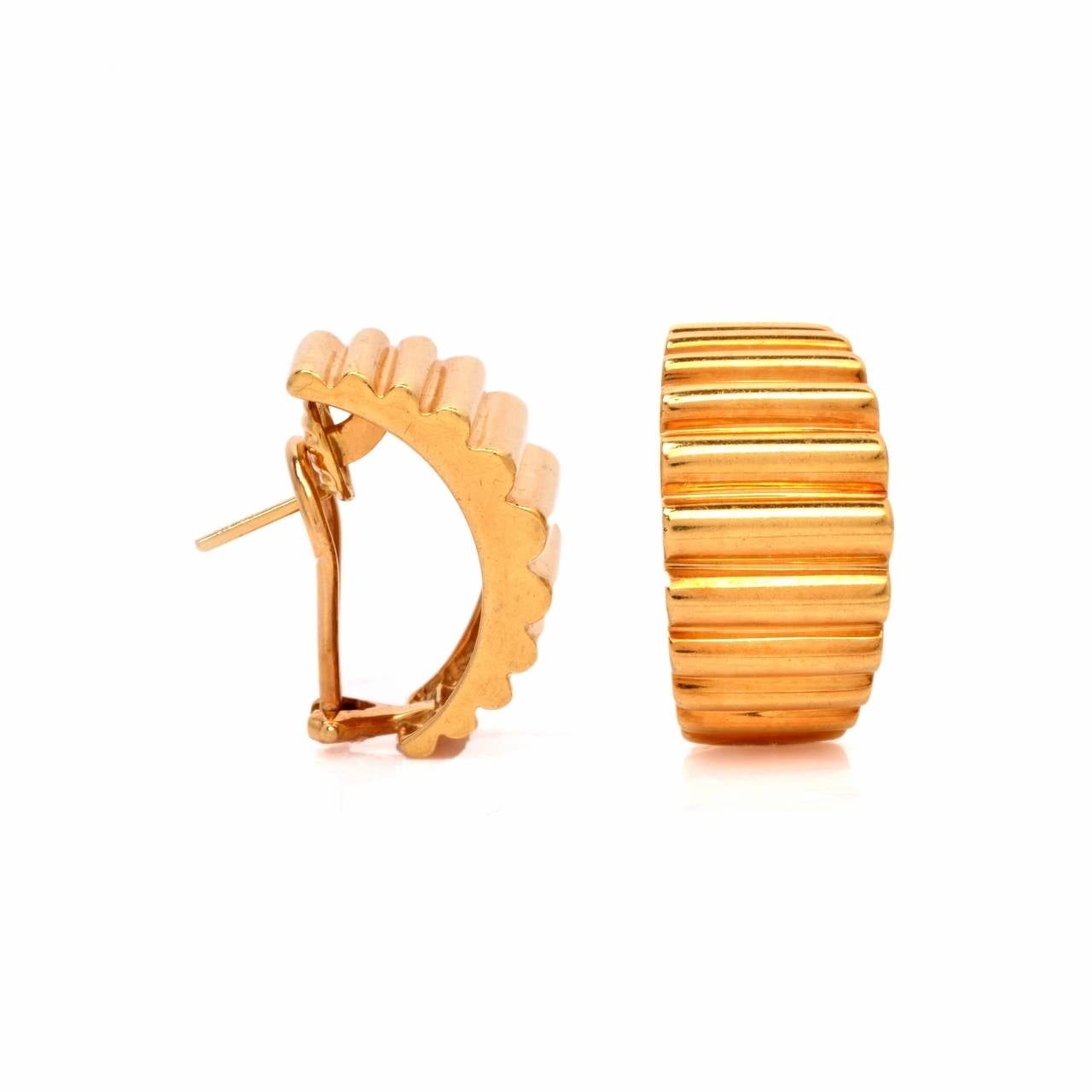 These exquisite estate designer earrings 'Tiffany & Co.' are crafted in solid 18K yellow gold. Showcasing a classic huggie design with fine engraved lines to accentuate the overall design. These earrings come with security french clip backs and are