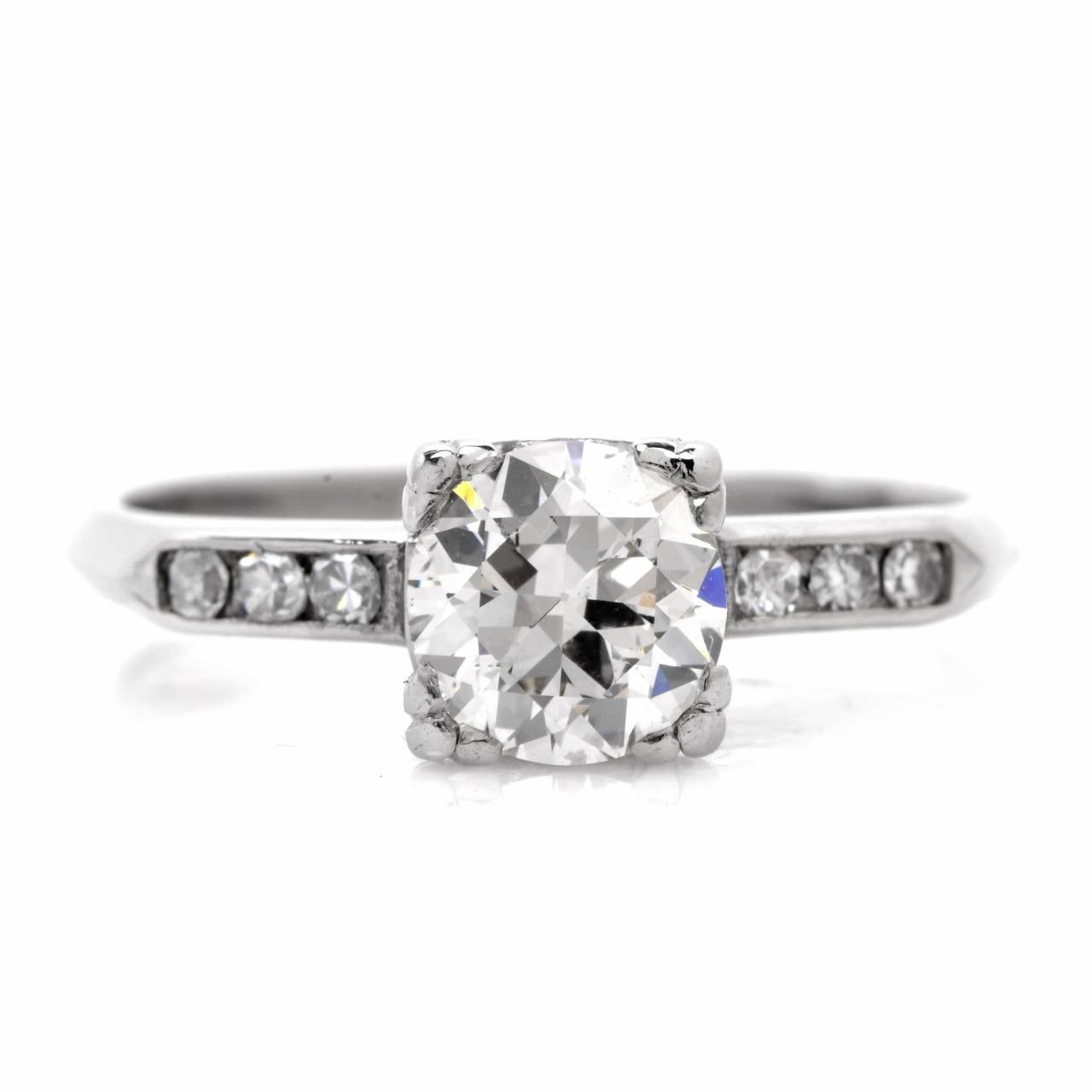 This gorgeous Antique  ring is crafted in solid  platinum. Showcasing a classic design that is centered with a beautiful round European cut diamond approx: 0.90cttw, I color,  very nice SI1 clarity  and is complemented by 6 genuine round cut smaller