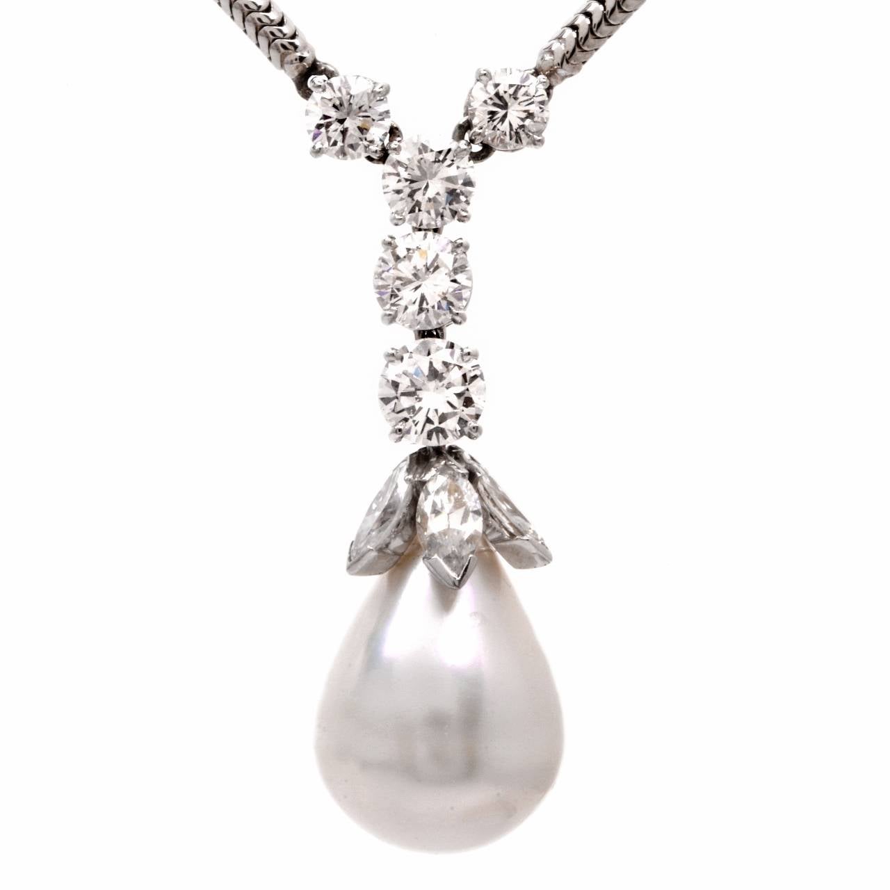 This beautiful pendant necklace with a pear shape Baroque pearl and  marquise and round-faceted diamonds is crafted in 18k gold.  The eye -catching pearl is  surmounted by a vertical diamonds row composed of 5 graduated round faceted large diamonds