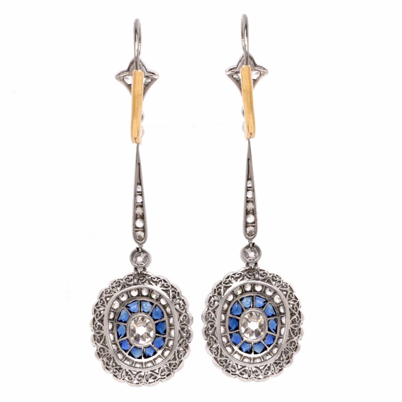 These exquisite diamond  and sapphire pendant  earrings are crafted in solid platinum, weighing app. 7.7 grams. These earrings expose a pair of  genuine cushion- cut diamonds, cumulatively weighing  app.0.70 cts, graded  H-I  color,  VS  clarity.