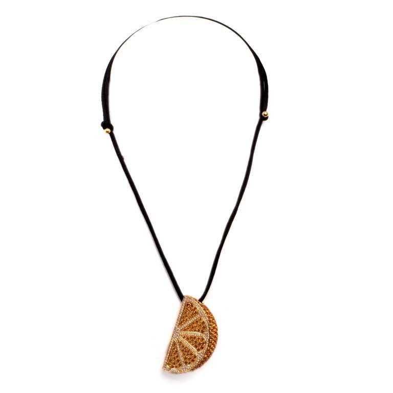 This  estate pendant necklace of creative design is crafted in solid 18K yellow gold, with a supporting black velvet ribbon.   It is designed to simulate an orange slice and is encrusted with 150 genuine round cut diamonds of approximately 2.20 cts,