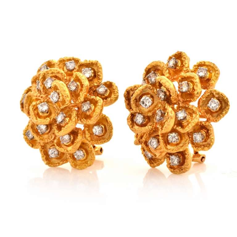 These vintage clip-back earrings of alluring feminine grace and immaculate craftsmanship are crafted in solid 18K yellow gold. Designed as an assemblage of delicate floral motif profiles, crafted in artfully textured gold, these earrings are totally