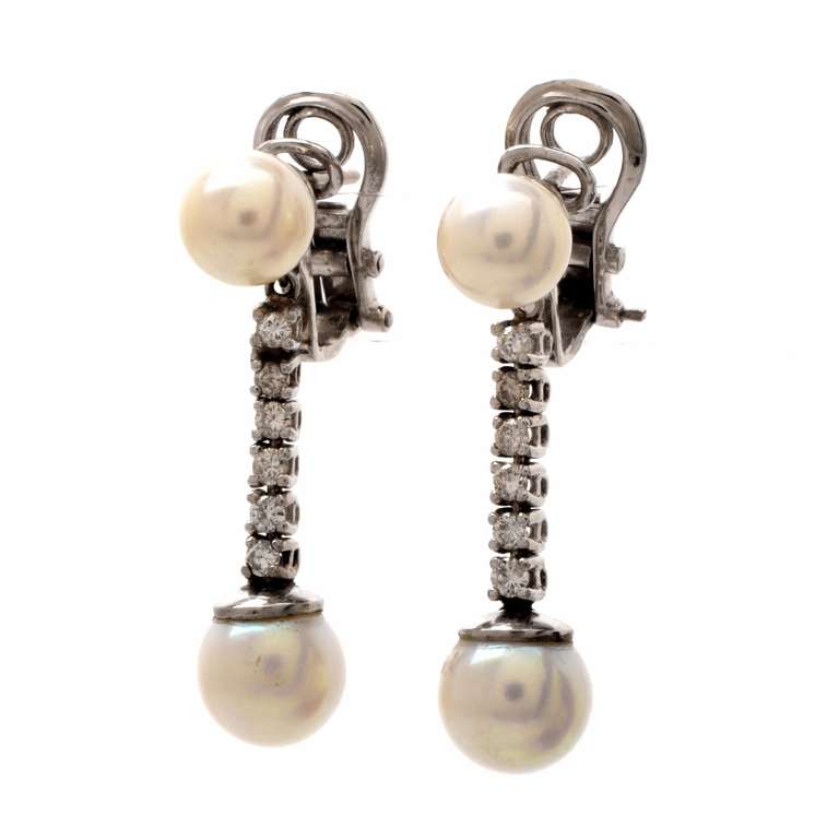 These vintage earrings with genuine saltwater pearls and diamonds are crafted in solid platinum, weigh approximately 9.3 grams and measure 1 1/4