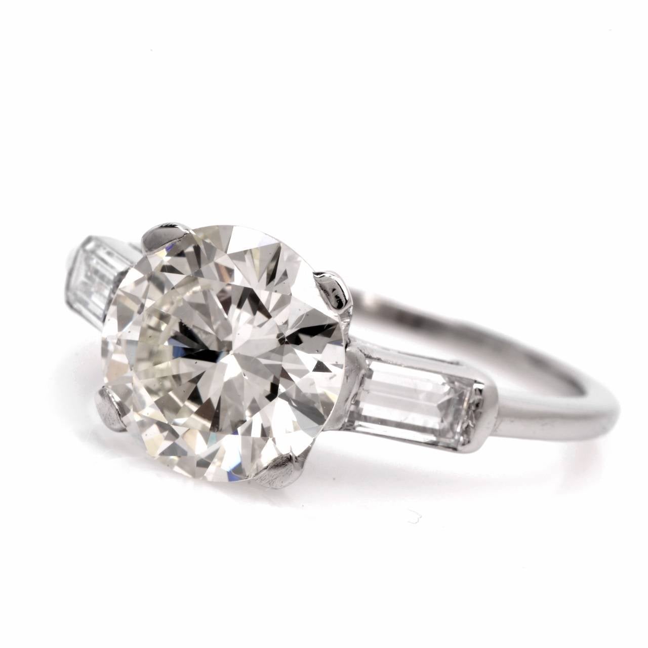 This  classically distinct  estate  engagement ring  is crafted in solid platinum and weighs 4.00 grams. Designed with  simplicity yet timeless elegance and  and  feminine grace, this  diamond engagement ring exposes at the center a genuine, round