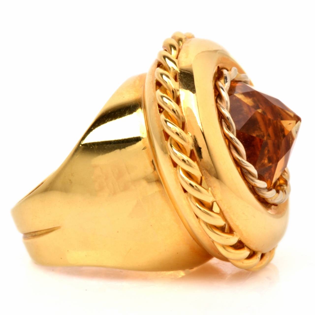 This opulent and impressive estate ring from the Retro era is crafted in solid 18K yellow gold and  weighs 18.8 grams. Inspired by the popular Medieval rings often set with semi-precious gemstones atop a sizable round plaque, this impressive estate
