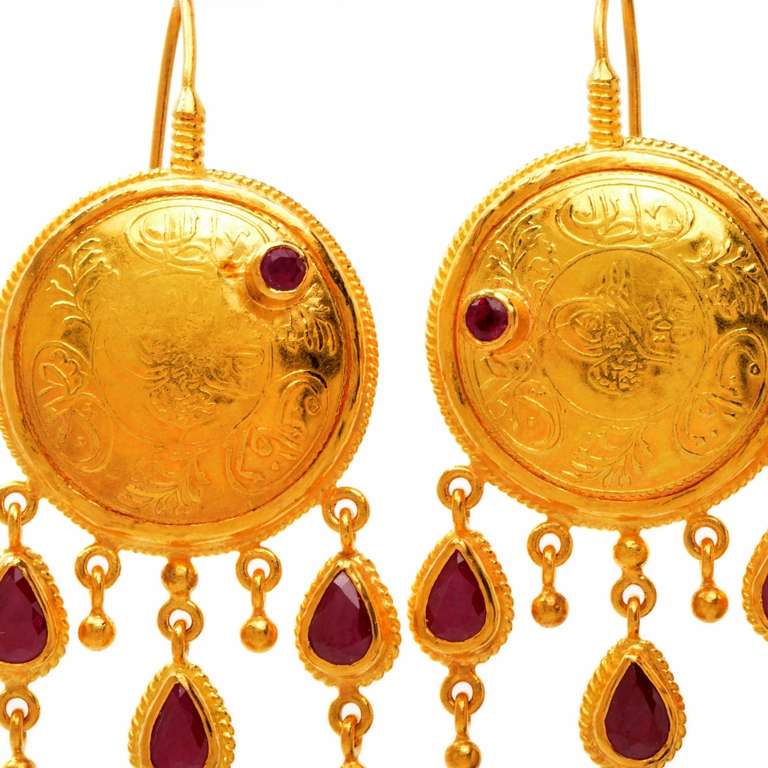 Dover Jewelry presents these gorgeous designer drop dangle 23K yellow gold earrings. Showcasing a beautiful and detailed filigree like design, these earrings are adorned with 2 genuine round cut red ruby gems and 6 genuine pear cut red ruby gems all