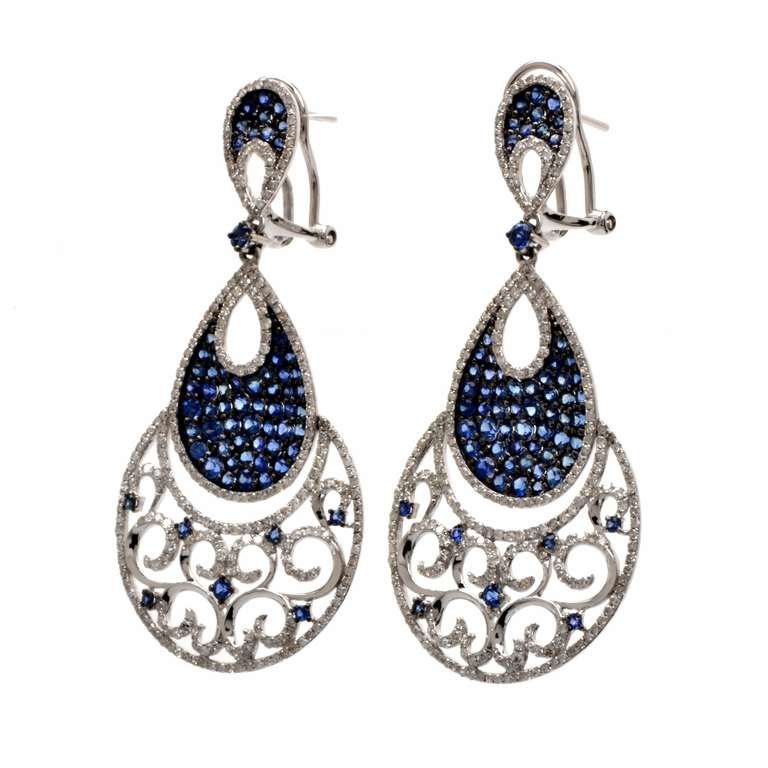 These impressive chandelier earrings with pave-set diamonds and blue sapphires are crafted in solid 18K white gold and weigh approx. 11.8 grams. Inspired by the late Victorian chandelier earrings following the popular design of the Iberian