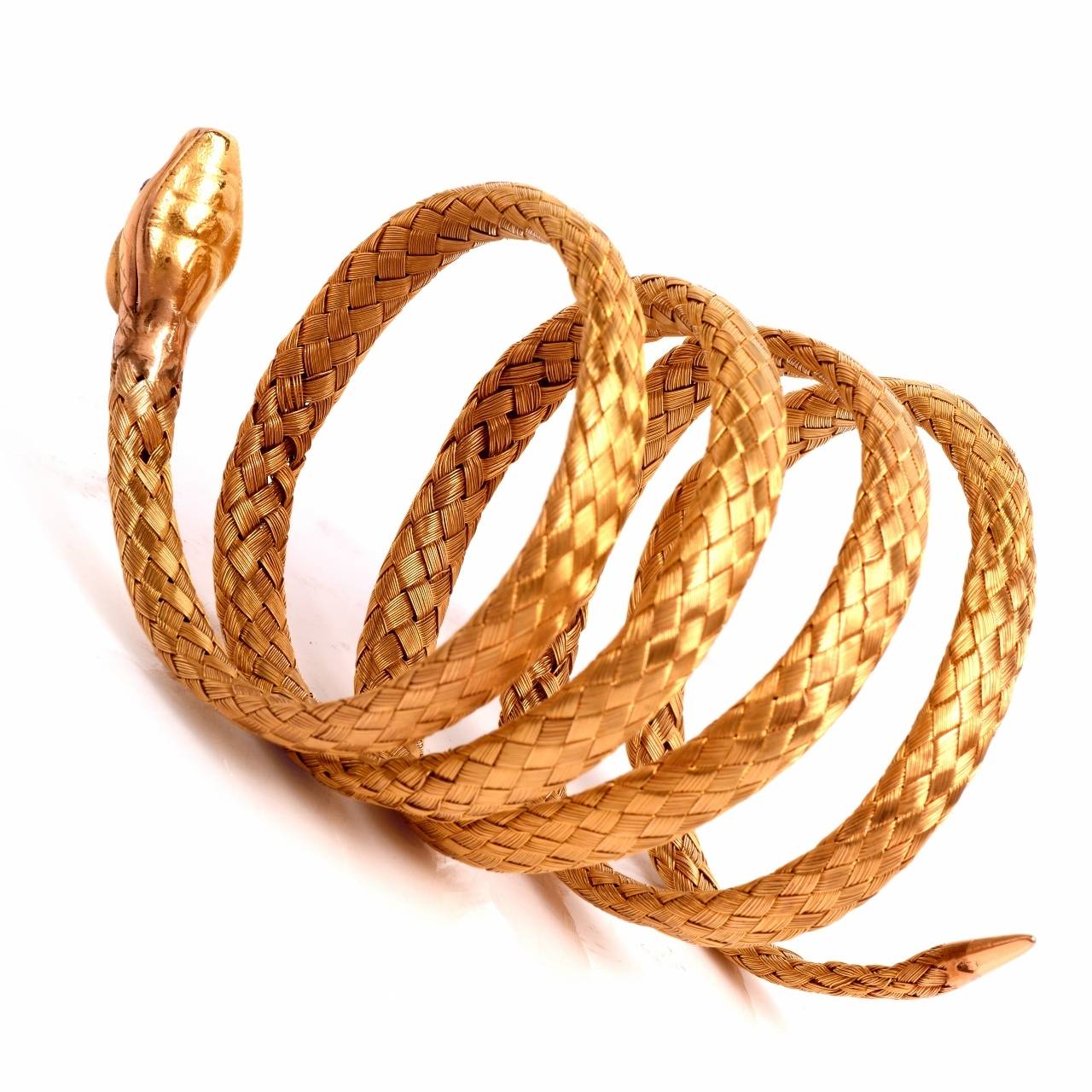 This fascinating antique flexible bracelet of artistic design and meticulous craftsmanship is rendered in an enchanting woven pattern in solid 18K yellow gold, weighing approximately 57 grams. This alluringly feminine bracelet depicts the 