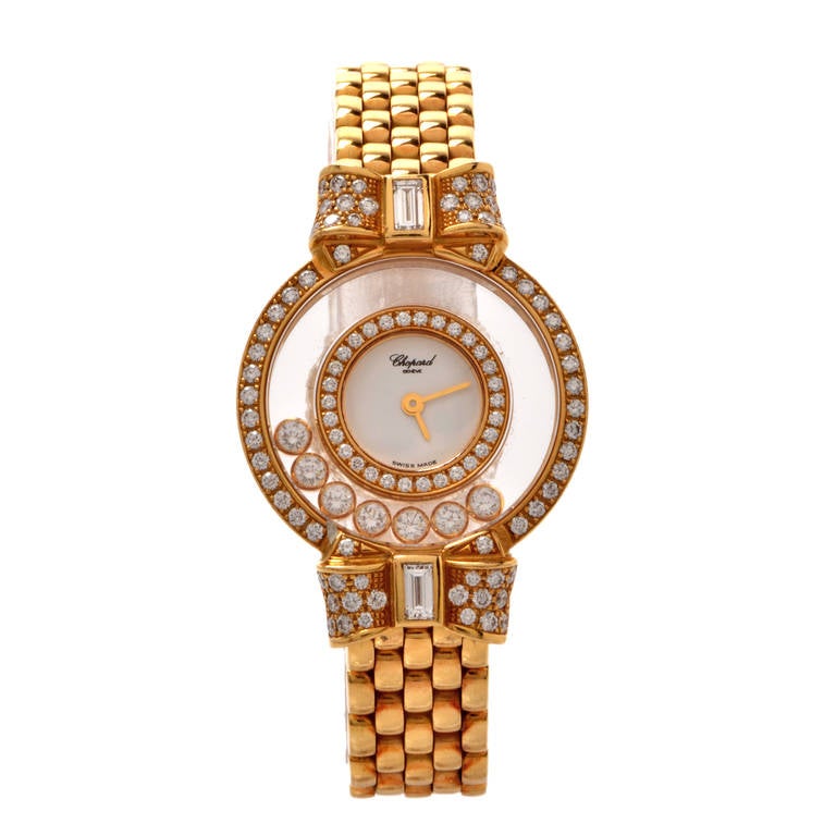 This classically distinct Swiss Chopard lady's watch from Chopard's Happy Diamonds collection features a transparent case measuring 23mm in diameter. Seven floating diamonds surround the dial while the case and the dial are enriched with two diamond
