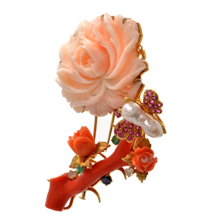 This authentic Retro lapel brooch and pendant of  artistic design and meticulous craftsmanship is crafted in  solid 18K yellow gold, weighing approx. 42.4 grams. Designed as a naturalistically inspired flower on stem, with enchanting 'buds' in coral