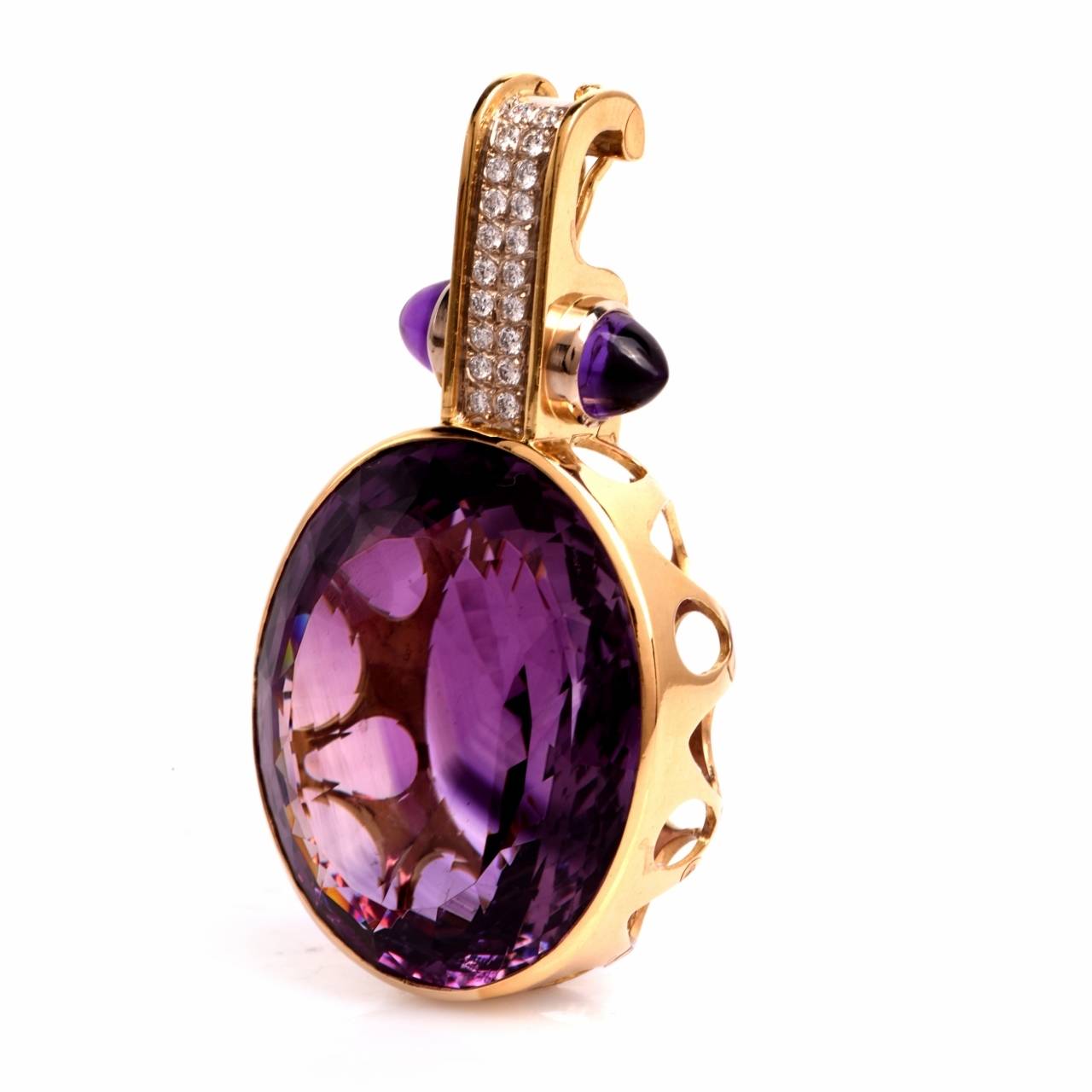 This opulent and attention-seeking Retro  pendant necklace is crafted in solid 18K yellow gold and weighs 47.5 grams. This eye-catching large pendant exposes an outstanding  103.55 ct oval-faceted amethyst, positioned within an ornate, openwork