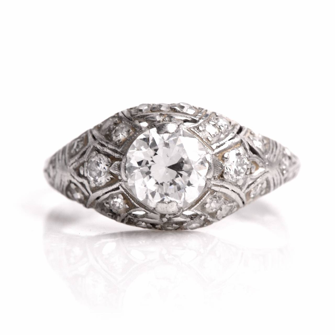 This antique  filigree engagement ring from the 1930's vintage era  is crafted in solid platinum, weighs approximately 3.00 grams and measures 5 mm high. Designed as a gracefully  domed  plaque, this delicate  vintage engagement ring exposes a
