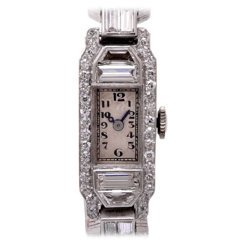 This beautiful lady's vintage watch is crafted in solid platinum. The filigree bracelet is accented with some 124 round cut diamonds, 10 baguette cut diamonds, and 2 pear cut diamonds all approx. cttw, 9.35 color, G-H VS clarity. Silvered dial, and