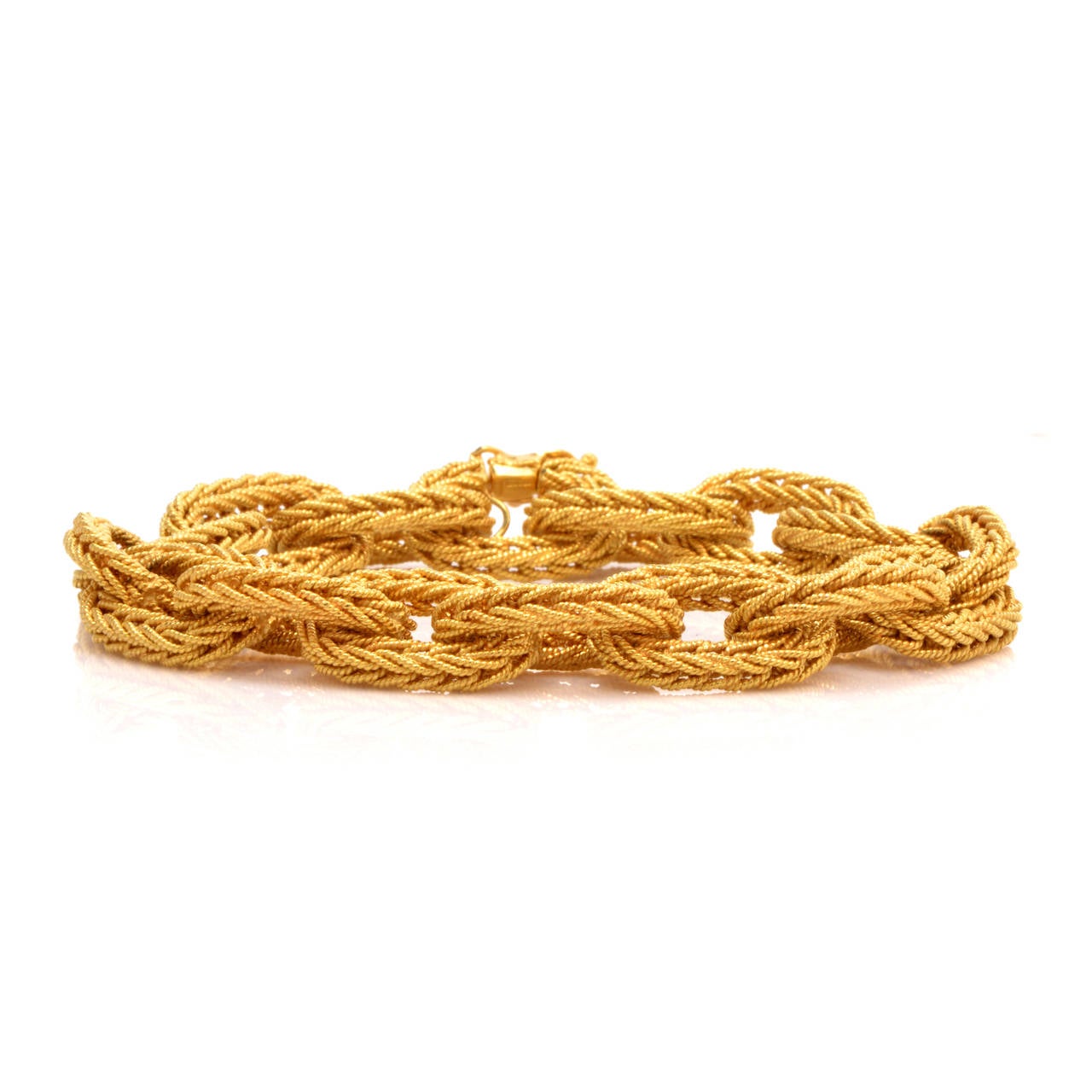 This retro link bracelet of  unsurpassed refinement is of Italian provenance, crafted in solid 18K yellow gold and weighs 51.7 grams. This immaculately crafted bracelet incorporates 16 inversely intertwined ovular links rendered in meticulous