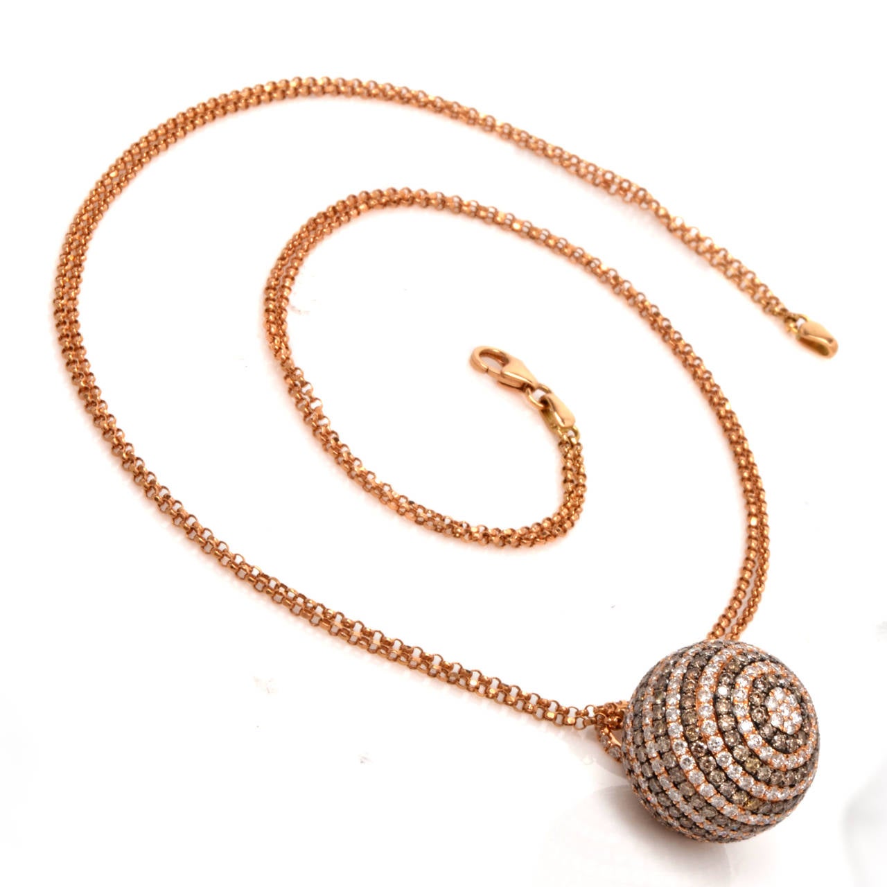 This pendant necklace with genuine pave-set fancy natural color and white diamonds is crafted in solid 18K rose gold.  This alluring necklace of notable refinement incorporates a ball-shaped pendant,  resplendent in 15 horizontal rows of alternately