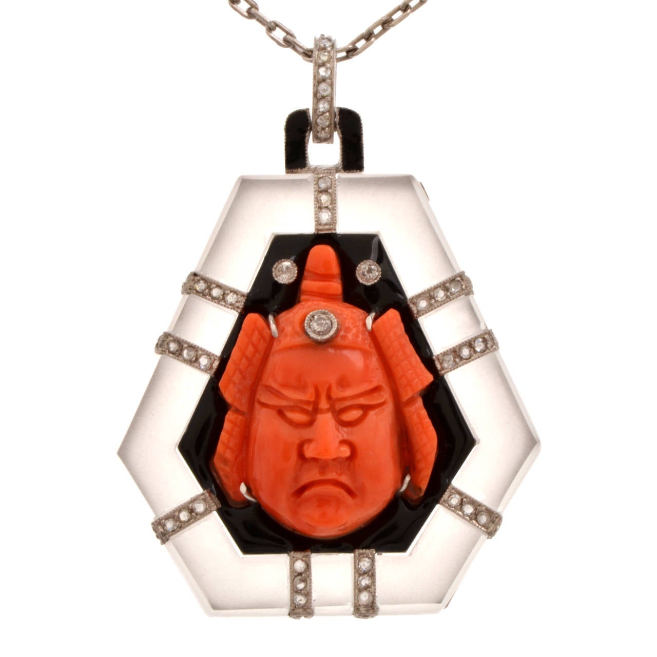 This Art Deco pendant necklace of artistic craftsmanship consists of a coral, onyx and diamond pendant and a platinum supporting chain. The pendant of hexagonal design depicts the artistically carved cameo portrait of a  Japanese warrior Samurai
