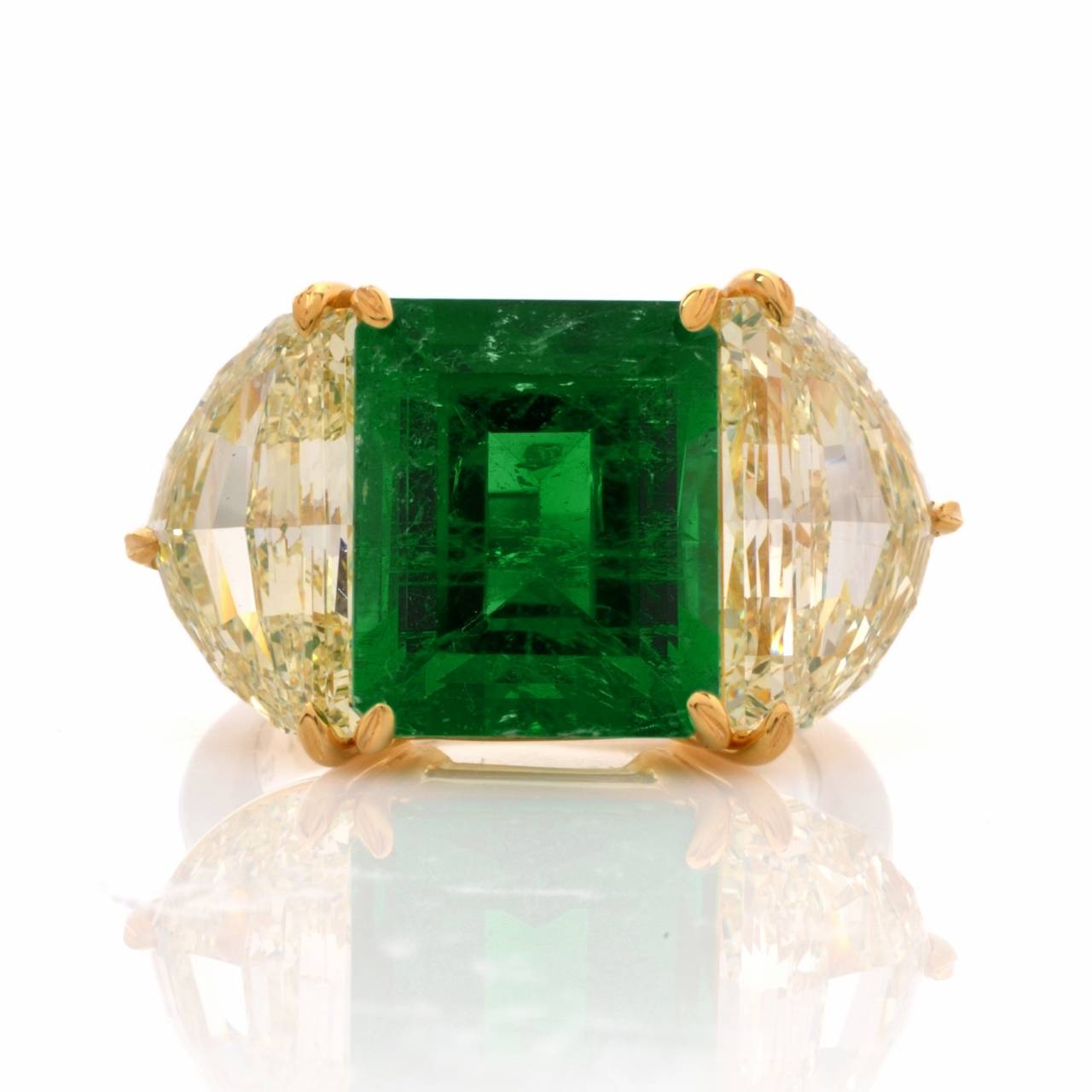 This aesthetically arresting and affluent cocktail ring with a prominent AGL certified genuine 6.70ct very fine natural Colombian emerald and a duo of  outstanding antique cut half-moon diamonds is crafted in a combination of solid platinum and 18K