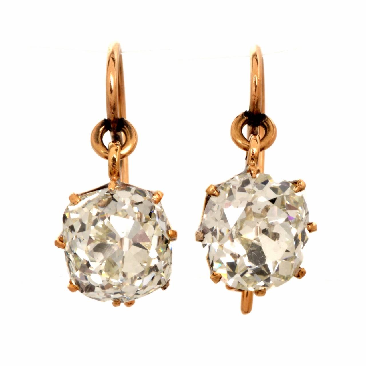These alluring antique earrings of timeless elegance and captivating aesthetic are crafted in solid 18K rose gold and weigh 5.7 grams.  These alluring earrings expose a pair of genuine oldmine-cut diamonds cumulatively weighing approx. 6.80 cts,