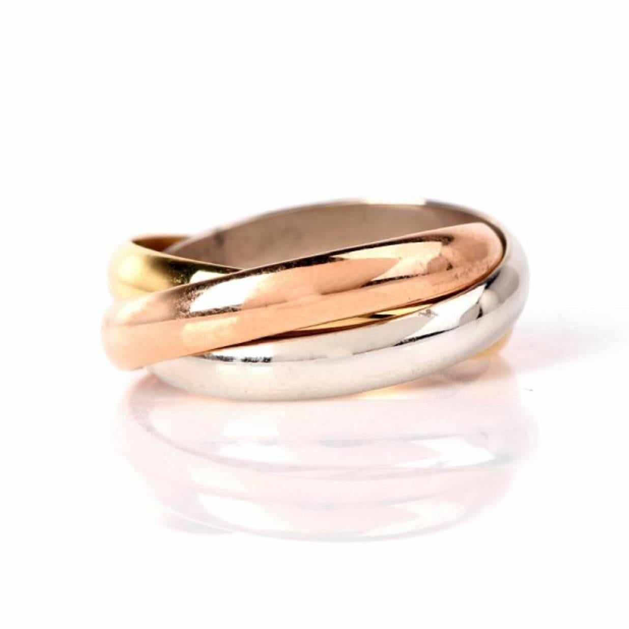 This Cartier trinity ring is crfted in a combination of solid 18K yellow, white and rose gold, weighing 12.6 grams, The trio of rings when worn measure measure 12 mm wide.  The Trinity ring is sjigned 'Cartier' for authencity, and bears the Ref. # 