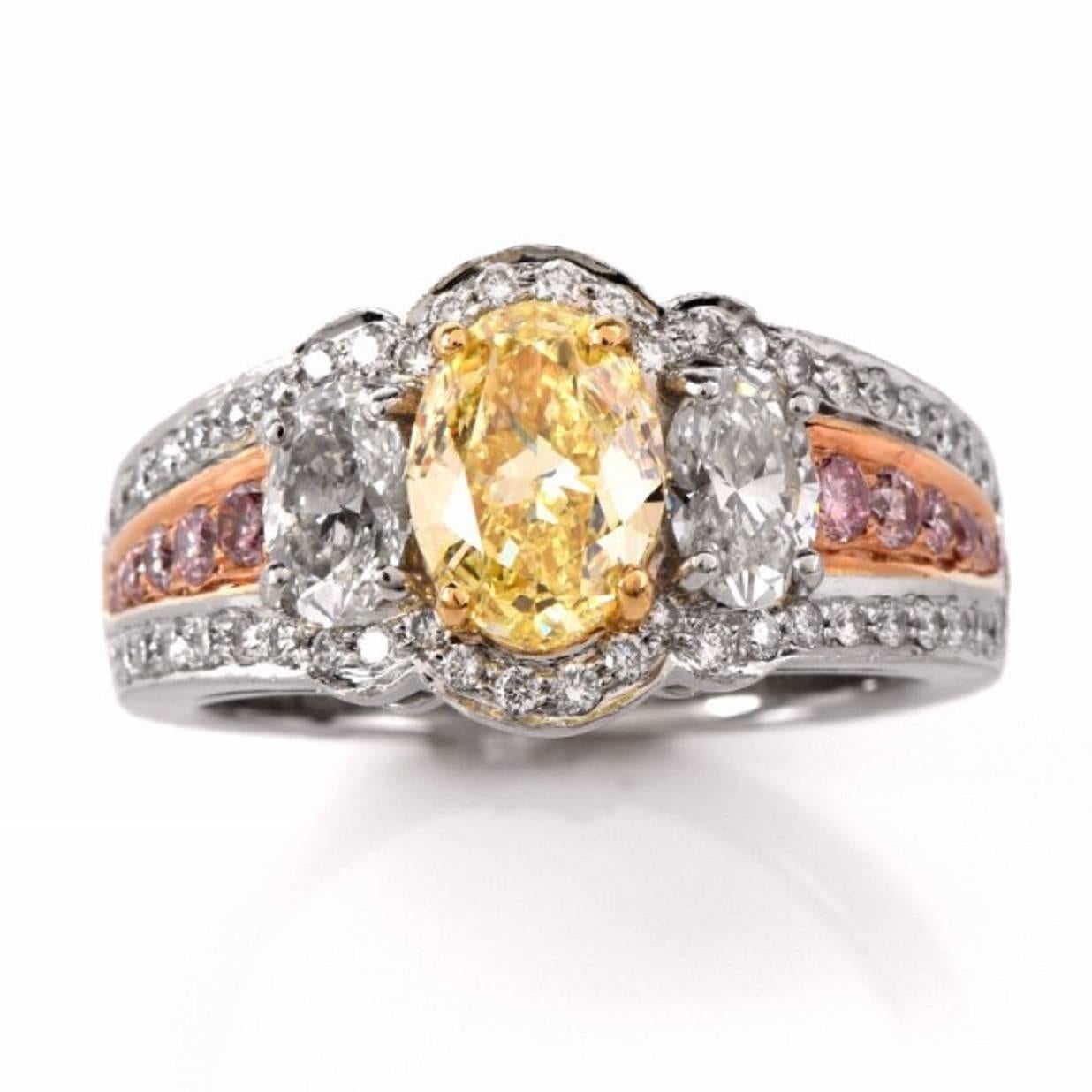 This designer Charles Krypell engagement ring with a GIA certified oval-faceted fancy yellow and colorless marquise diamonds  is crafted in solid platinum with a touch of 18K yellow gold applied to the setting of pink diamonds on the shoulders. The