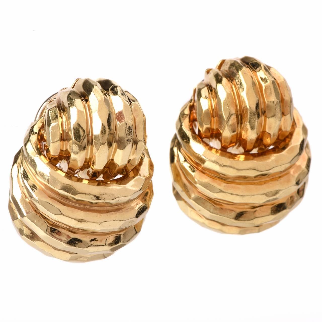 These classically elegant earrings designed by Henry Dunay are crafted in solid 18K yellow gold with artistic hammered texture, weigh 29.00 grams and measure 27 x 21 mm. Creatively designed as combination of 'swirl-and-knot' profiles embellished