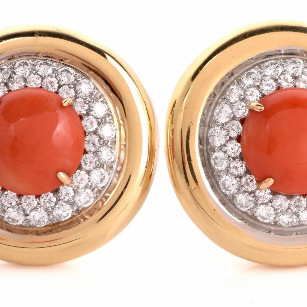 These colorful estate earrings are crafted in solid 18K yellow gold. They weigh approx. 33.8 grams and incorporate orbicular plaques centered with a pair of reddish salmon color natural coral cabochons approx. 12mm, surrounded by sparkling diamond