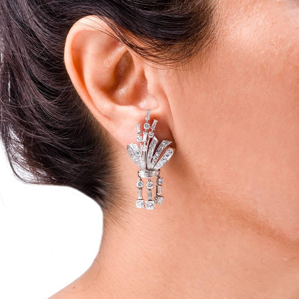These classically distinct diamond cluster earrings are crafted in solid platinum with gold backs, weigh 16.9  grams and measure 42 mm long and 20 mm wide. Simulating  stylized floral sprays with alluring, diamond swathed ribbon bows, resembling a