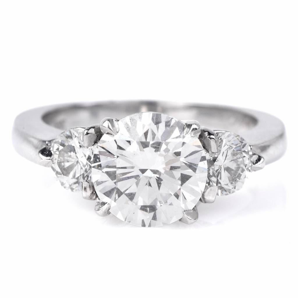 This classic diamond engagement ring is crafted in solid platinum. It centered with a genuine GIA  round brilliant cut diamond weighing approx. 2.09 carats, F color, SI1 clarity and accented with 2 genuine round cut diamonds approx 0.80 carats, F