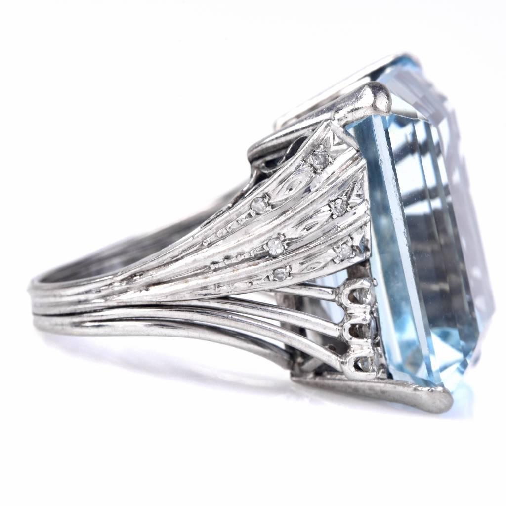 This glamourous aquamarine diamond cocktail ring is crafted in solid platinum weighing approx. 11.4 grams and measuring 22mm by 21mm, 12mm high. The center exposes a genuine emerald cut flawless Aquamarine approx 22.36cttw, and is accented with some