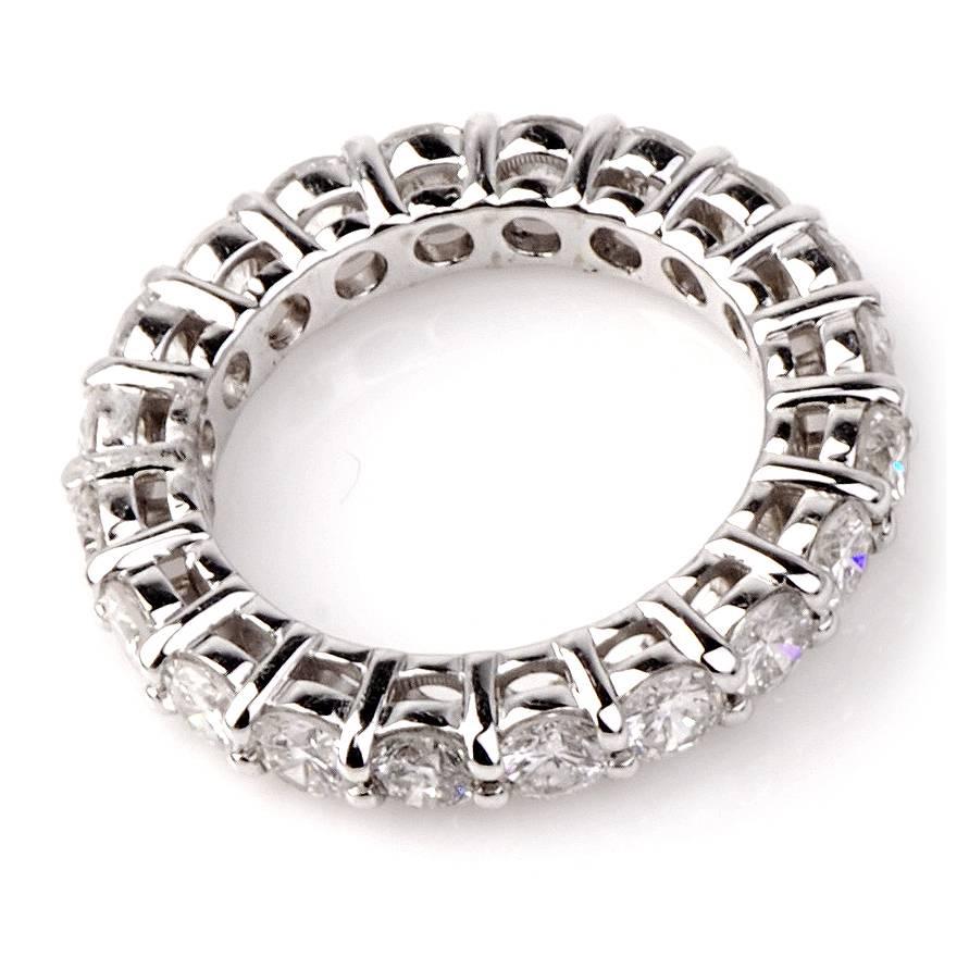 This classic estate eternity band of outstanding sparkle is crafted in solid 18K white gold. This elegant eternity band features 20 genuine prong-set round-faceted diamonds, cumulatively weighing 3.75cts, graded H color and VS1 clarity, and remains