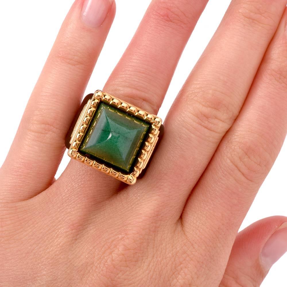 This extravagant ring of unique design exposes a pyramidal jadeite approx. 15mm x 15mm within an ornately designed yellow gold frame. The eye-catching jadeite is complemented by artfully carved black onyx gallery, shoulders and shank, with an