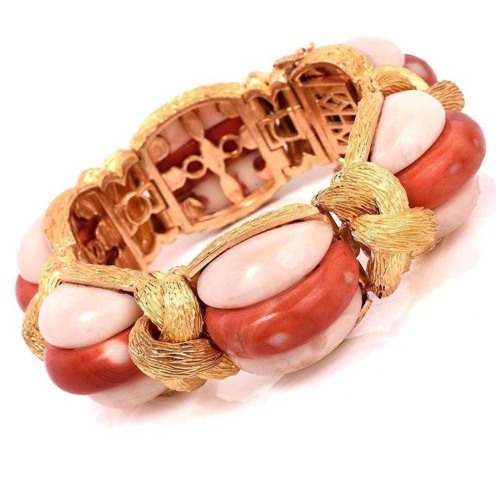 This extravagant one of a kind French bangle bracelet features 18 half moon cut natural Corals in red and light pink colors set apart with bark textured 18K yellow gold knot links.This bangle bracelet comes with a double insert security clasp and a