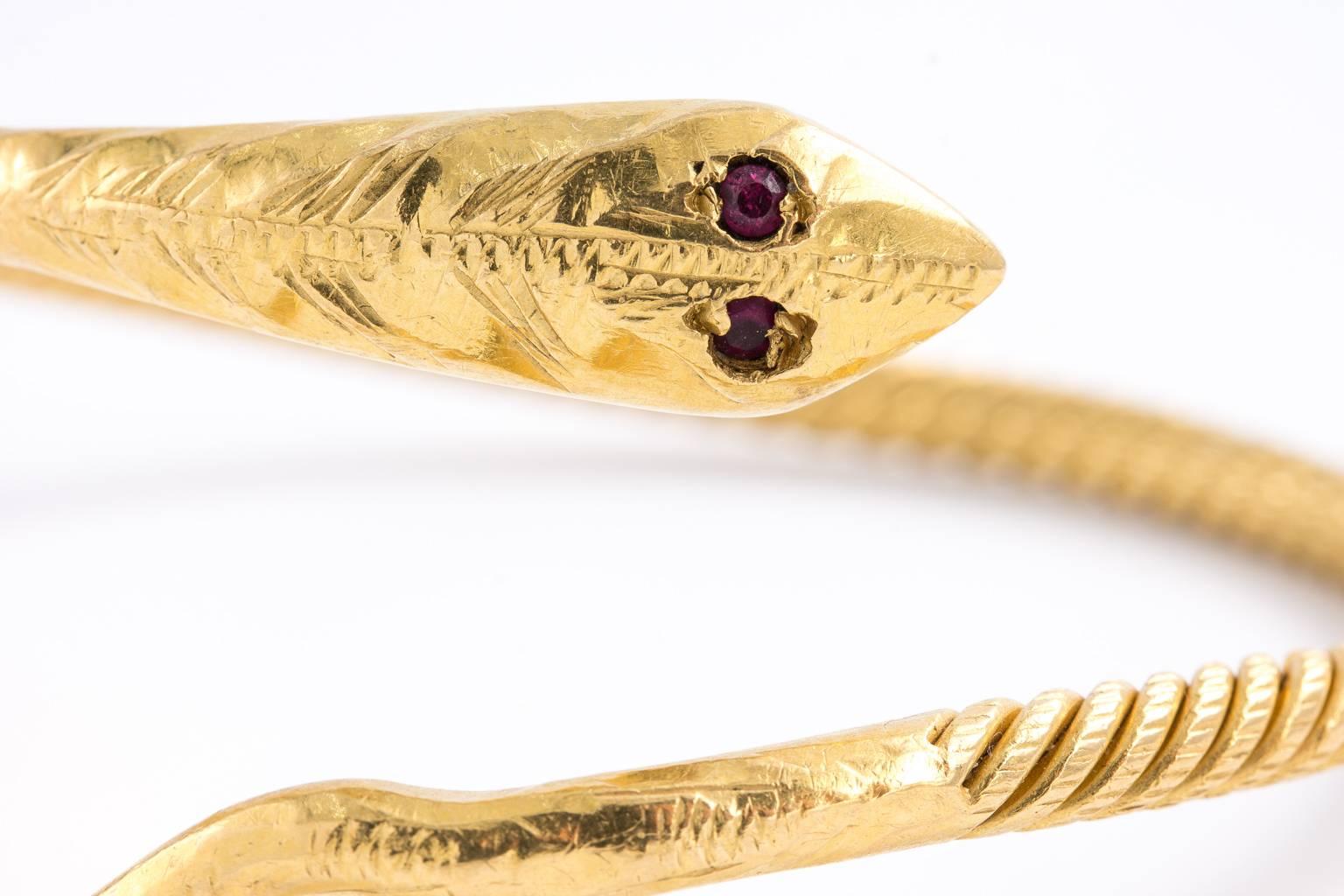 An elegant high carat late Deco bangle of highly coveted serpent's body. Hand made to resemble the markings on a serpent. Beautiful ruby eyes. Snake jewelry are a symbol of good luck and good fortune. Very stunning. Weighs 44.10 grams.