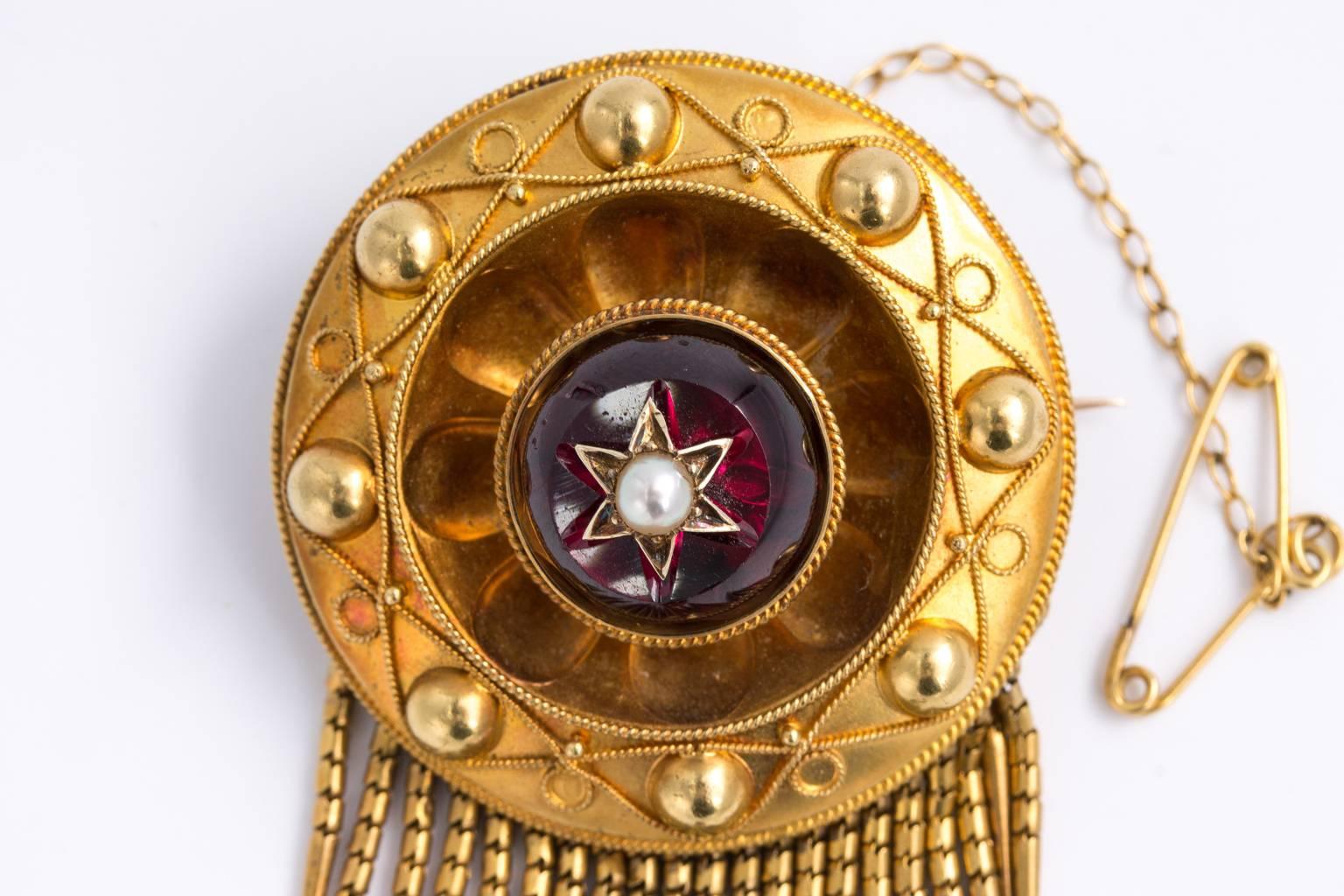 A superb English Mid Victorian 1860's 15 kt locket brooch with its own original box. the front having finely engraved surround. The center set with faceted casbashiang shaped garnet with pearl inserts and granulated flexible fringe featuring central