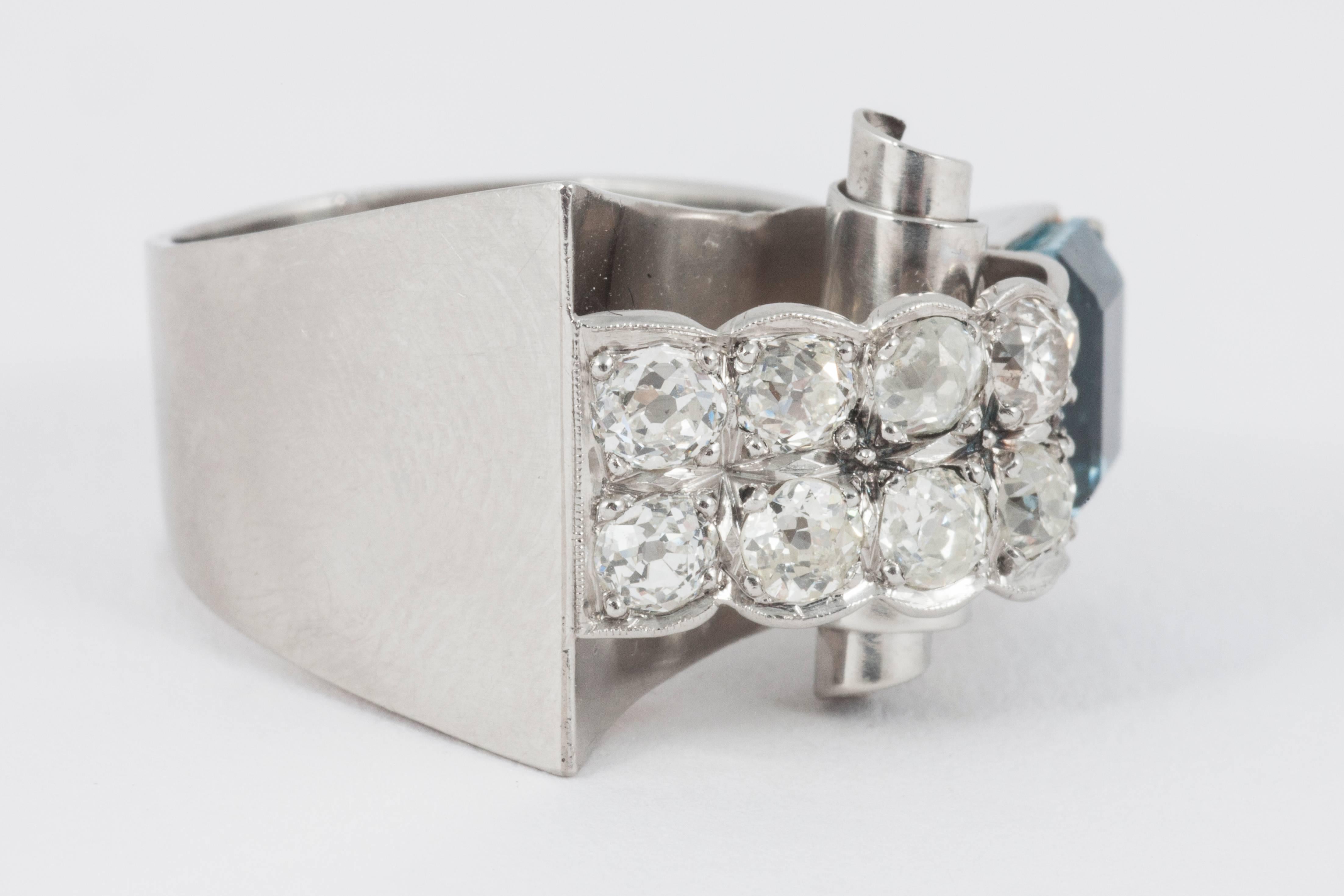 A platinum set aquamarine, & diamond cocktail ring containing a baguette cut aquamarine & 10 old round brilliant-cut diamonds, circa 1940’s