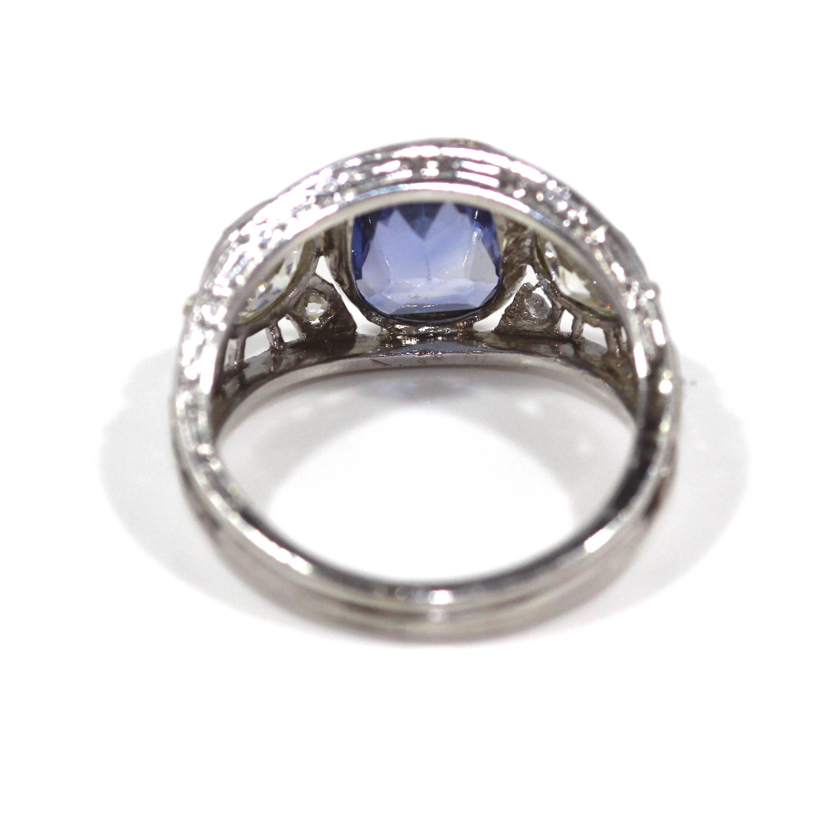 A 1920's cushion cut sapphire and diamond 3 stone cluster ring set in platinum. 

