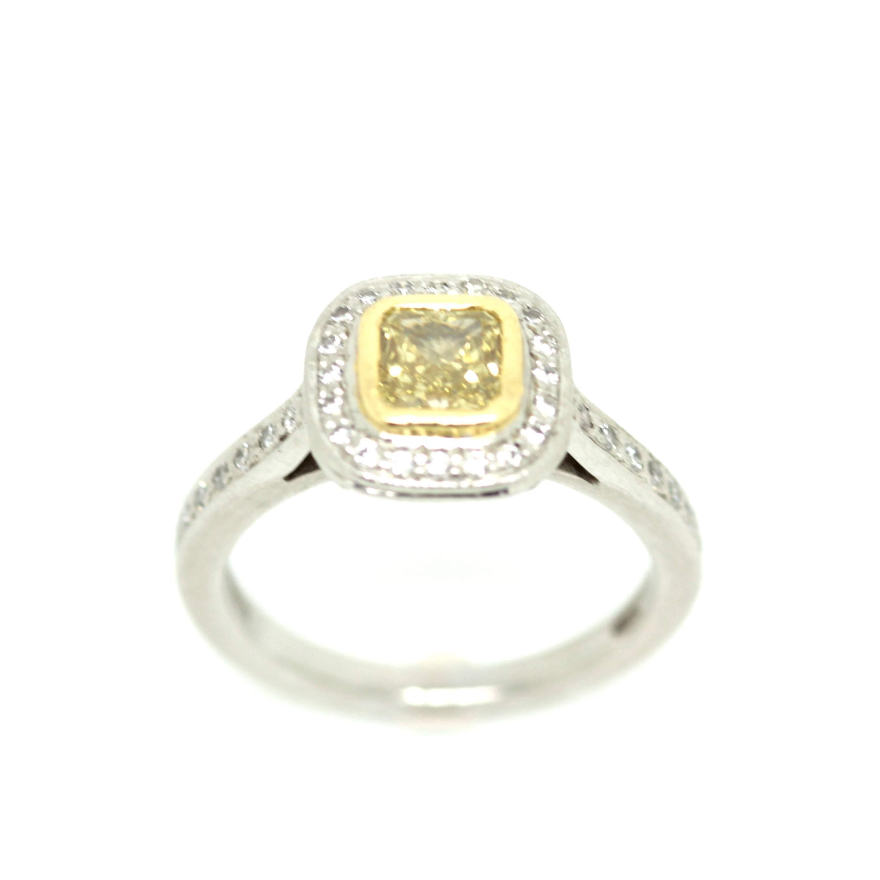 A 0.66ct Square modified brilliant, fancy intense yellow, VS2 clarity, GIA certified diamond, set in a platinum diamond cluster setting. Circa: recent 
