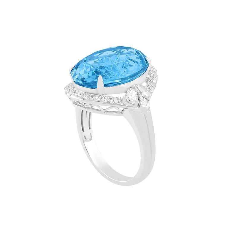 Dieser kühne, strahlende und kunstvoll gearbeitete 13,10-karätige Schweizer Blautopasring ist ein atemberaubendes Schaufenster der Farbe und Eleganz. In glänzendem 18-karätigem Weißgold gefasst, ziert das Herzstück ein kunstvoll geschnitzter ovaler