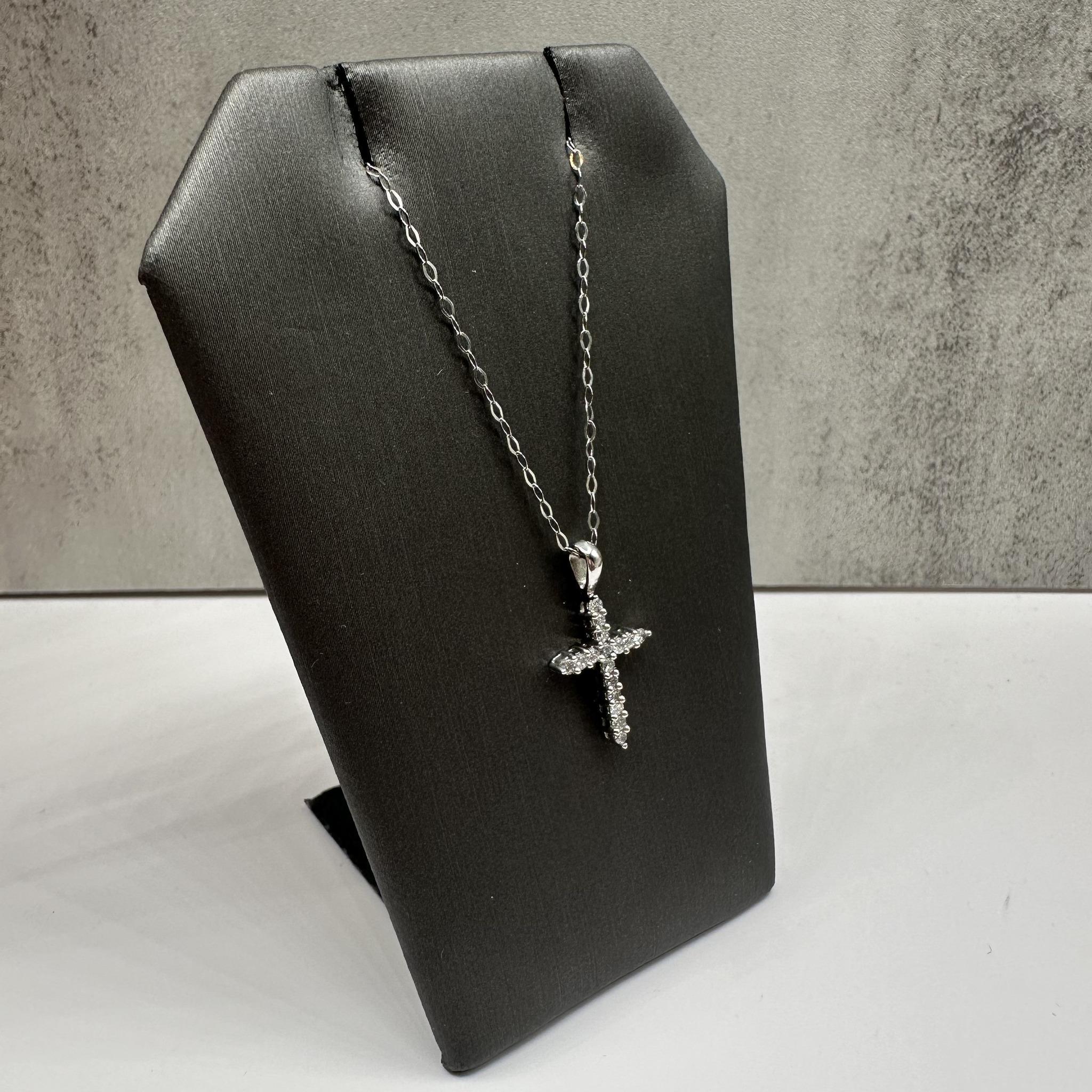 Cet élégant collier croix à diamants en platine présente environ 0,25ctw de diamants ronds GH I1, ajoutant un éclat brillant au design intemporel de la croix. La longueur de 18 pouces s'adapte confortablement au cou, et le fermoir à anneau à ressort