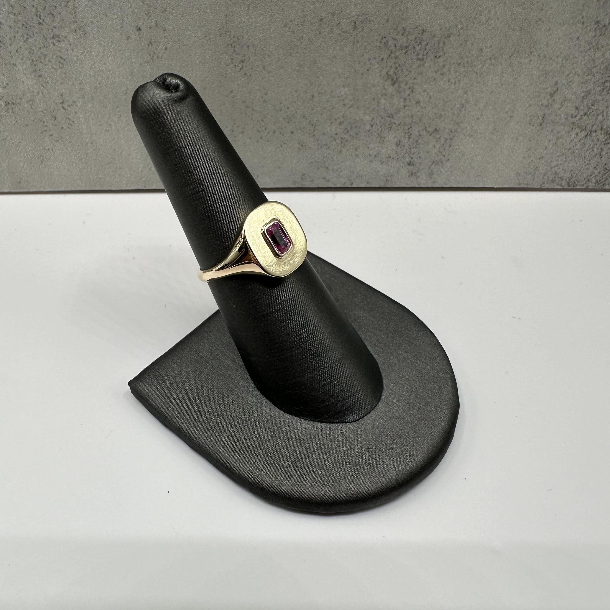 Cette élégante bague à chaton en saphir rose en or jaune 14kt est ornée d'un saphir rose de 0,41ctw taillé en émeraude, d'une belle teinte vibrante. Avec un poids de 3.4 grammes, il offre une sensation de solidité et de confort au quotidien. Avec
