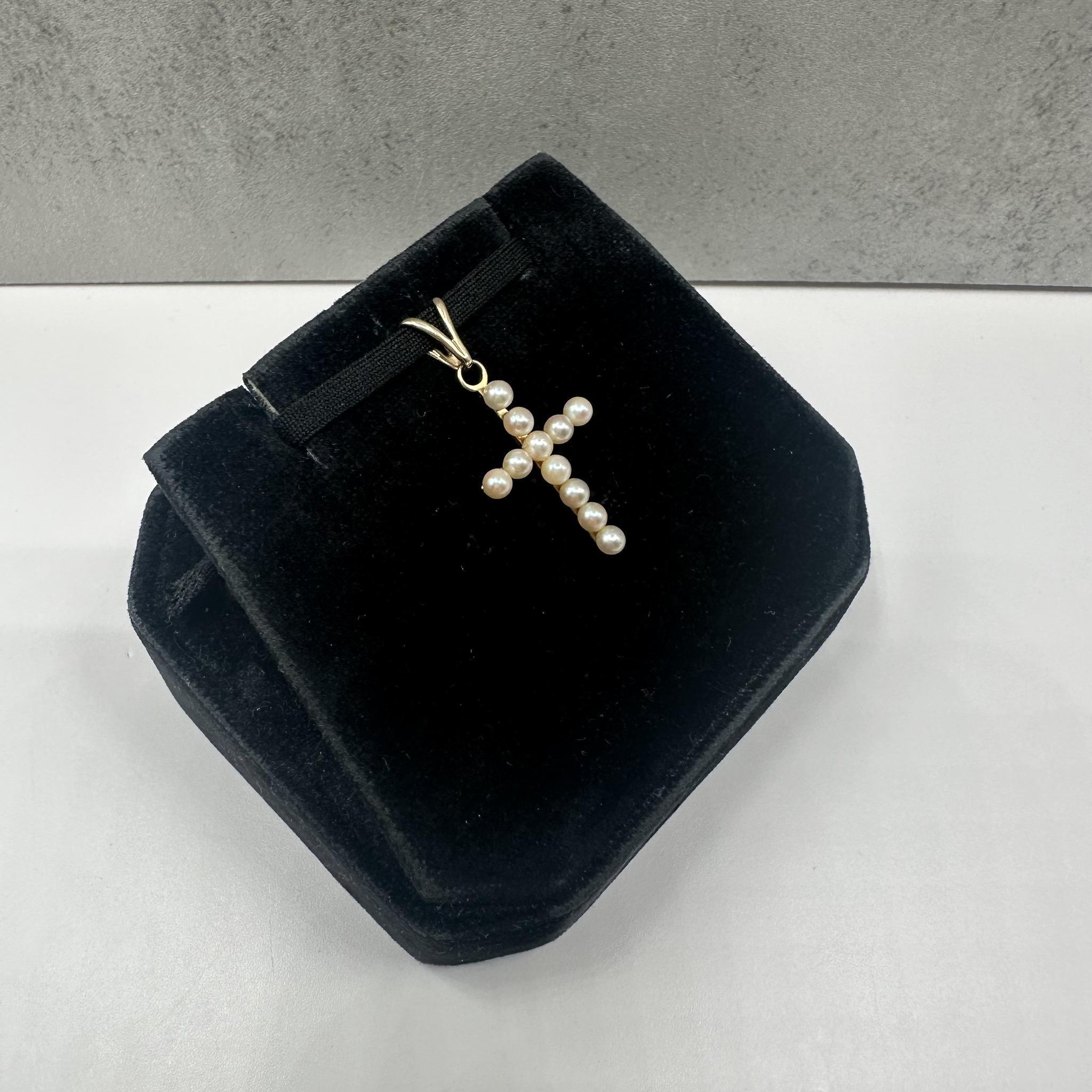 Cette élégante croix de perles Estate en or jaune 14kt est ornée de petites perles rondes, qui ajoutent une touche douce et intemporelle au design classique de la croix. Avec un poids de 1.09 gramme, il est léger et confortable à porter au